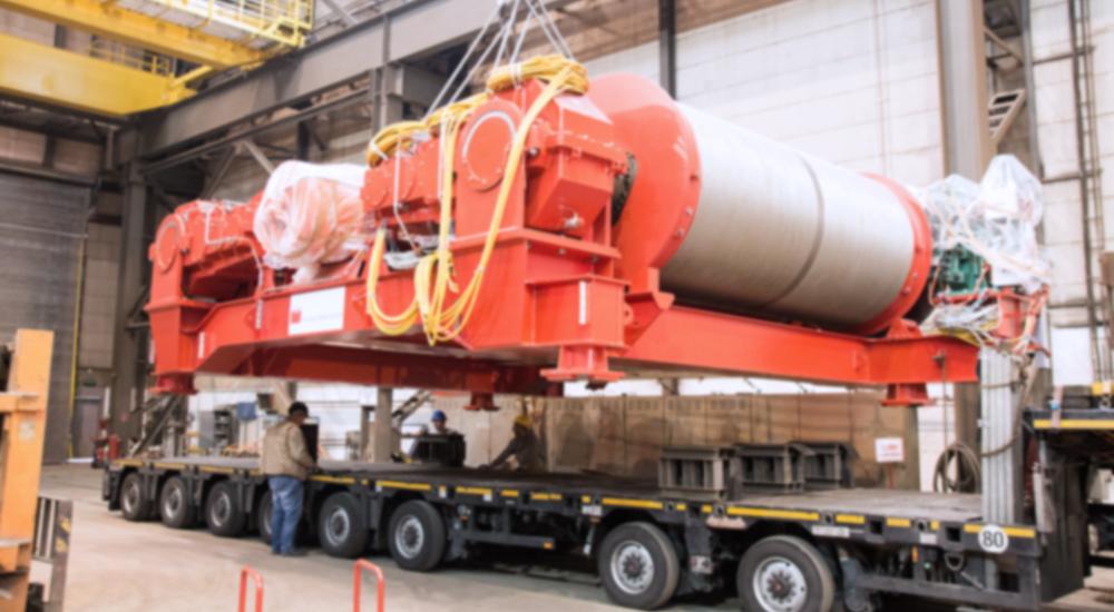 Loading an oversized crane component onto a heavy trailer.